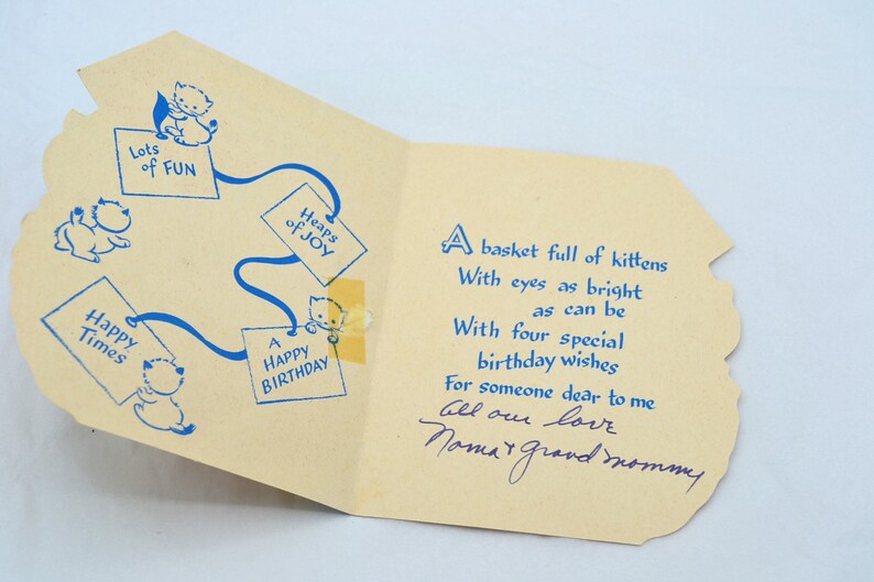 K&ouml;nnte beinhalten: Eine Vintage-Geburtstagskarte mit einer blauen und wei&szlig;en Illustration von K&auml;tzchen und dem Text "Ein Korb voller K&auml;tzchen mit Augen, die so hell sind wie m&ouml;glich, mit vier besonderen Geburtstagsw&uuml;nschen f&uuml;r jemanden, der mir am Herzen liegt. Alles Liebe, Mama und Oma."