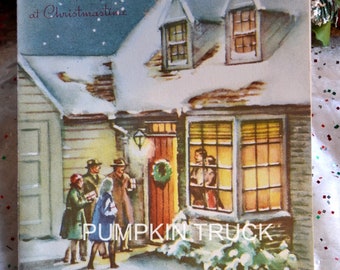 May include: Vintage Christmas card featuring a snowy house with people gathered outside the door. The card has the text "A Wish for Gladness at Christmastime" and a wreath on the door. The image is a nostalgic illustration.
