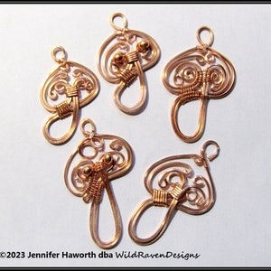 May include: Five copper wire mushroom charms with a swirl design and gold beads. The charms are approximately 2 inches in length.