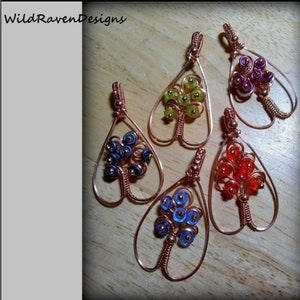 May include: Five copper wire tree of life pendants with different coloured beads. The beads are green, purple, blue, red, and light blue.