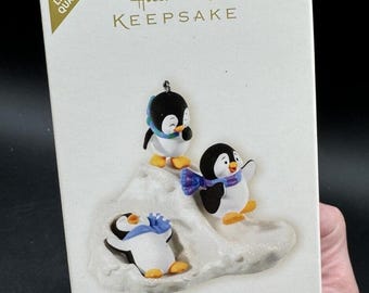 May include: A Hallmark Keepsake Christmas ornament featuring three penguins in a snowy scene. The ornament is part of the "Slippin' and Slidin' Special Edition" collection. The text "2008 Limited Quantity" is visible in the upper left corner.