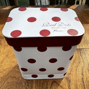 Puede incluir: Caja de regalo blanca con lunares rojos y tapa burdeos. La caja tiene el texto "Red Dots tea for one Rosanna" impreso en la tapa.