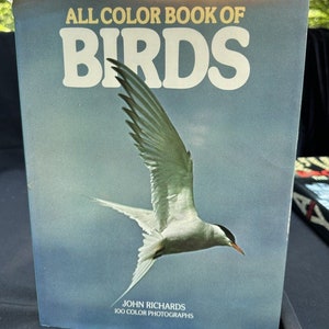 May include: A book titled "All Color Book of Birds" by John Richards with 100 color photographs. The cover features a white bird with black markings flying against a blue sky.