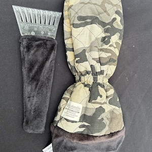 Könnte beinhalten: Ein Eiskratzer mit einem schwarzen Plüschgriff und einem Camouflage-Muster-Fäustling. Der Fäustling hat ein gestepptes Design und eine schwarze Plüschmanschette. Der Eiskratzer hat eine transparente Kunststoffklinge.