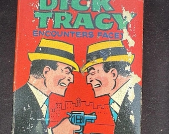 May include: A vintage comic book cover for "Dick Tracy Encounters Face!" with green text on a red backdrop. Two men in suits and fedoras are depicted aiming blue revolvers. The cover shows signs of wear and tear, indicating its age.