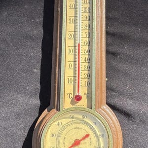 Puede incluir: Termómetro e higrómetro Sunbeam vintage. El termómetro muestra escalas Celsius y Fahrenheit, con un indicador rojo. El higrómetro es circular, con una aguja que indica el nivel de humedad. Fabricado en EE. UU.