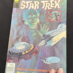 Puede incluir: Una portada de cómic vintage de Star Trek con el profesor Whipple, naves espaciales y el logotipo de Star Trek. La portada tiene una etiqueta de precio de 35 centavos y el texto "¡Conoce a un doctor interplanetario!"