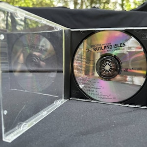 Può includere: Una custodia per CD nera con una copertina in plastica trasparente. Il CD all'interno è un disco argentato con un'etichetta nera che recita "Eric Idle Presents The Rutland Isles with your host Nigel Spasm". La lista delle tracce è stampata sull'etichetta.