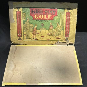 May include: Vintage Kro-Kay Golf game box with a yellow, green, and red design. The box features a family playing the game. The text on the box reads "Kro-Kay Golf" and "RUGG MANUFACTURING CO. GREENFIELD, MASS."