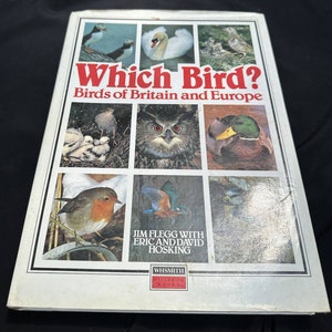 May include: A book cover with the title "Which Bird? Birds of Britain and Europe" featuring colorful images of various birds, including a puffin, a swan, an owl, a duck, a robin, and a kingfisher. The book is by Jim Flegg with Eric and David Hosking and is a Whsmith Exclusive.