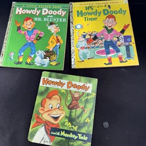 Peut inclure: Trois livres vintage "Howdy Doody" de la collection Little Golden Books. Les couvertures présentent des illustrations du personnage Howdy Doody, de Mr. Bluster et d'un singe. Les livres ont des couleurs vives, dont le vert, le jaune et le rouge, avec du texte en gras.