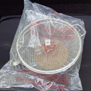 May include: A stainless steel mesh strainer with a circular design and two handles, packaged in a clear plastic bag. The strainer is designed for kitchen use, likely for draining or rinsing food items. A small tag is visible inside the bag.