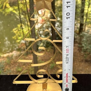 Op de afbeelding: Gouden metalen kerstboomversiering met een ster bovenop. De boom is ongeveer 30 cm hoog.
