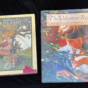 Puede incluir: Dos libros para niños, uno titulado "The Tale of Peter Rabbit and Other Stories by Beatrix Potter" y el otro titulado "The Velveteen Rabbit" de Margery Williams, con ilustraciones de Donna Green.