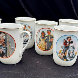 Puede incluir: Un conjunto de ocho tazas de cerámica blanca con bordes dorados. Cada taza presenta una ilustración vintage diferente en un marco circular. Las ilustraciones representan varias escenas, incluyendo personas y paisajes invernales.