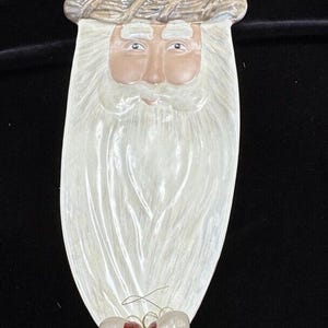 May include: White ceramic Santa Claus serving dish with a red hat and a white beard. The dish has three red and white acorns attached to the bottom.