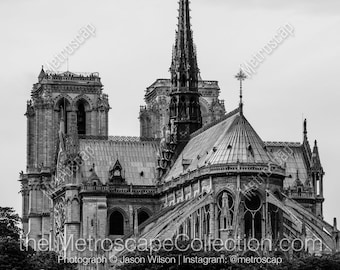 Puede incluir: Una fotografía en blanco y negro de la Catedral de Notre Dame en París, Francia. La foto muestra los intrincados detalles de la arquitectura de la catedral, incluyendo las torres, las gárgolas y las vidrieras.