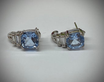 Cushion cut light blue CZ's faceted stone stud earrings.Below the blue stone are 2 clear baguettes. The earrings are very elegant and lovely