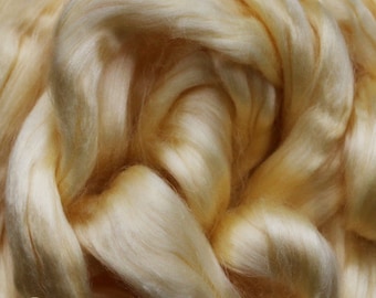 May include: Close-up of natural yellow silk fiber. The fiber is soft and fluffy, with a slightly golden hue.