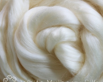 May include: Close-up of white mulberry silk fibres, soft and fluffy, with a text overlay that reads "White Mulberry Silk".