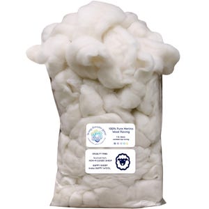 May include: A clear plastic bag filled with fluffy, white 100% pure Merino wool roving. The bag has two labels with text that reads "Living Dreams Yarn" and "Cruelty Free". The wool is sourced from non-mulesed sheep.