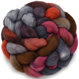 May include: A braided bundle of colorful wool yarn in shades of red, orange, brown, gray, and purple. The yarn is arranged in a circular shape, creating a visually appealing and textured display.