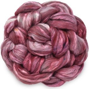 Könnte beinhalten: Ein Bündel aus rosa, weiß und grauem Merinowolle-Roving. Das Roving ist verdreht und geflochten, wodurch ein strukturiertes und flauschiges Aussehen entsteht.