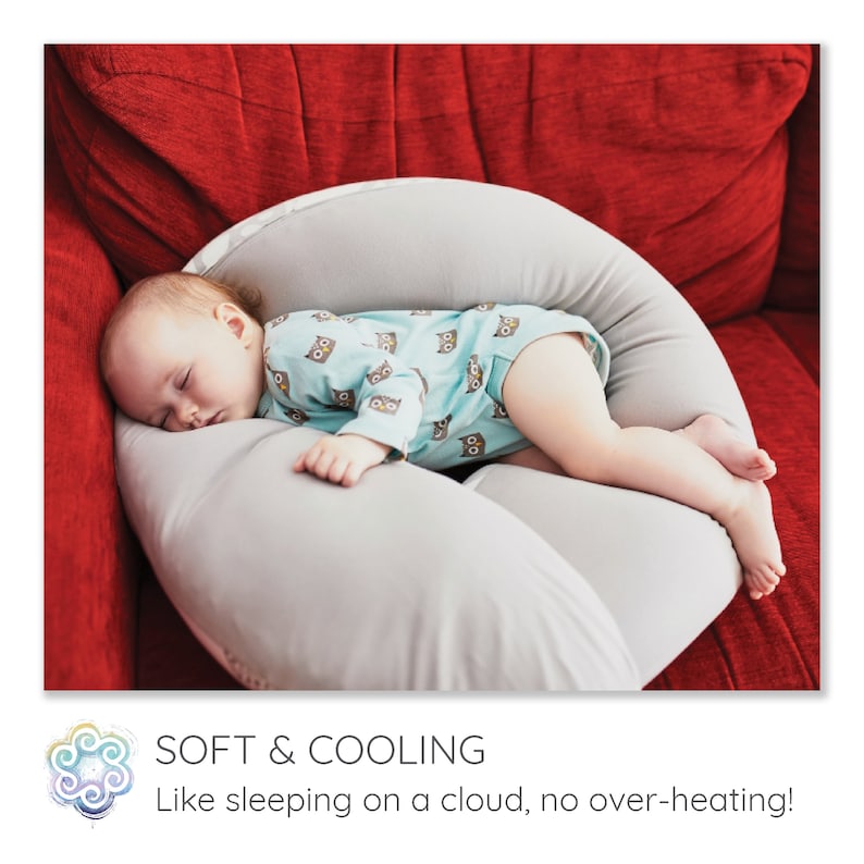 May include: A baby sleeping on a gray and white donut-shaped pillow. The pillow is on a red couch. The text "SOFT & COOLING Like sleeping on a cloud, no over-heating!" is below the image.