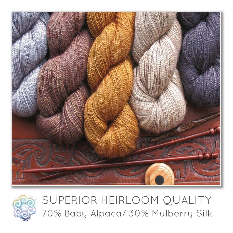 May include: Close-up of several skeins of yarn in shades of gray, brown, and gold. The yarn is arranged on a brown leather surface with carved designs. Two wooden knitting needles and a wooden yarn swift are also visible.