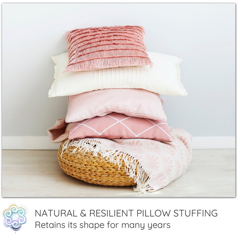 Peut inclure: Une pile de quatre coussins roses et blancs avec des d&eacute;tails en franges, pos&eacute;s sur un panier tiss&eacute; avec une couverture rose et blanche. Garnissage de coussin naturel et r&eacute;sistant. Conserve sa forme pendant de nombreuses ann&eacute;es.