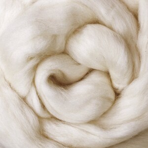 May include: A close-up of a soft, white, fluffy material. The material is arranged in a swirling pattern, creating a sense of texture and depth.