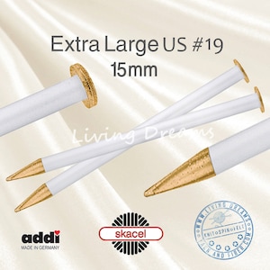 May include: A pair of white knitting needles with gold tips and a gold band at the end. The needles are 15 mm (US size 19) and are labeled "Extra Large US #19". The needles are made by Addi and are labeled "Made in Germany".