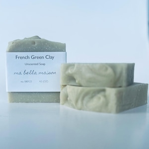 May include: Three bars of unscented French Green Clay soap. The front bar has a white label that reads "French Green Clay, Unscented Soap, ma bella maison, no. 080123, 4.5 (OZ)." The soap is a pale green color.