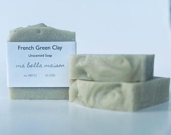 May include: Three bars of unscented French Green Clay soap. The front bar has a white label that reads "French Green Clay, Unscented Soap, ma bella maison, no. 080123, 4.5 (OZ)." The soap is a pale green color.