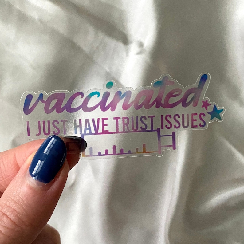 K&ouml;nnte beinhalten: Ein transparenter Aufkleber mit einem Regenbogen-Farbverlauf. Der Aufkleber sagt "geimpft Ich habe einfach Vertrauensprobleme" mit einem kleinen Stern neben dem Text. Eine Spritze ist unter dem Text abgebildet.