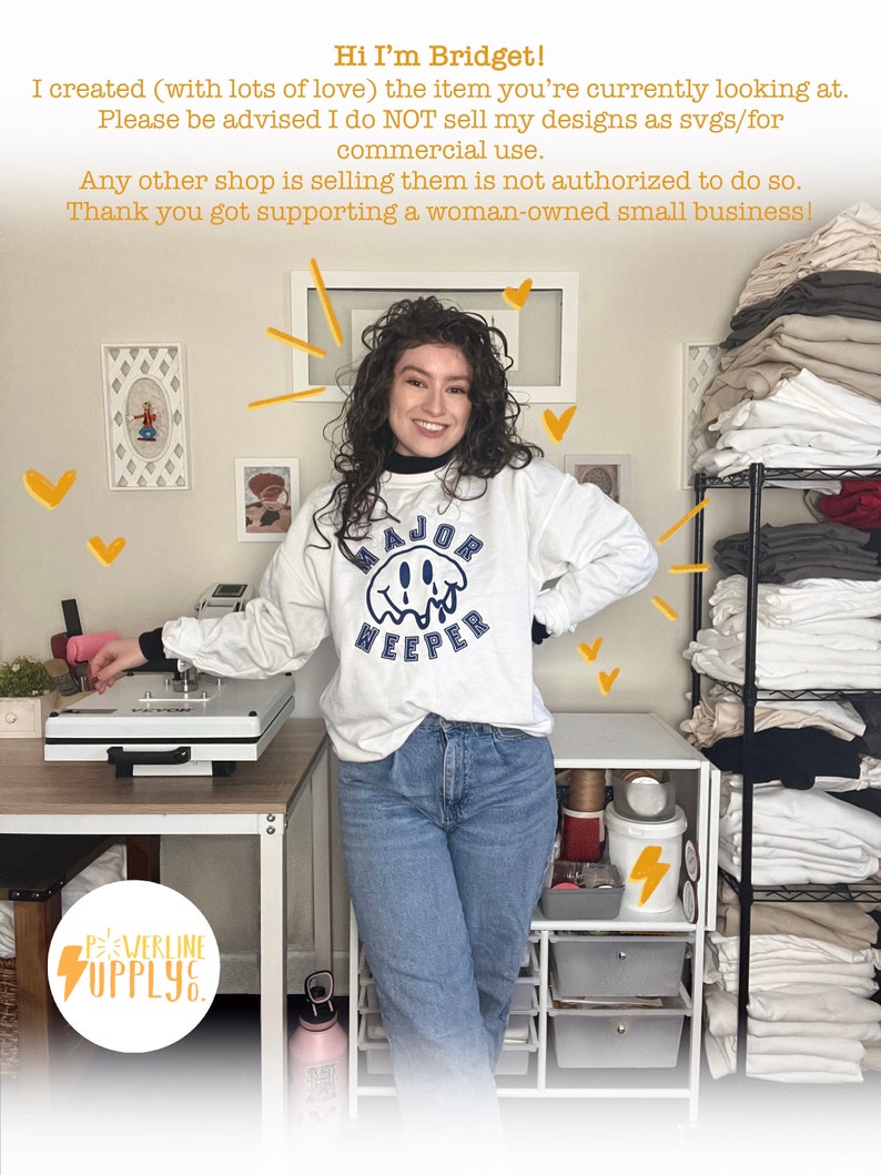 May include: A woman wearing a white sweatshirt with the text "MAJOR WEEPER" in blue lettering. She is standing in front of a white table with a heat press and a shelf unit with stacks of white t-shirts. The text "POWERLINE SUPPLY" is visible in the lower left corner of the image.