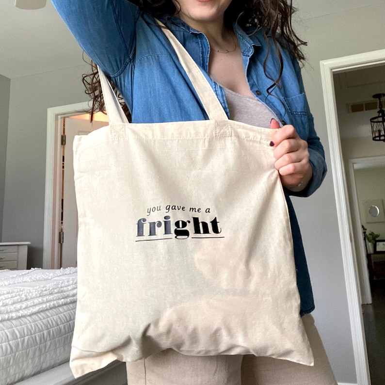 Op de afbeelding: Een beige tote bag met zwarte tekst die "you gave me a fright" zegt.