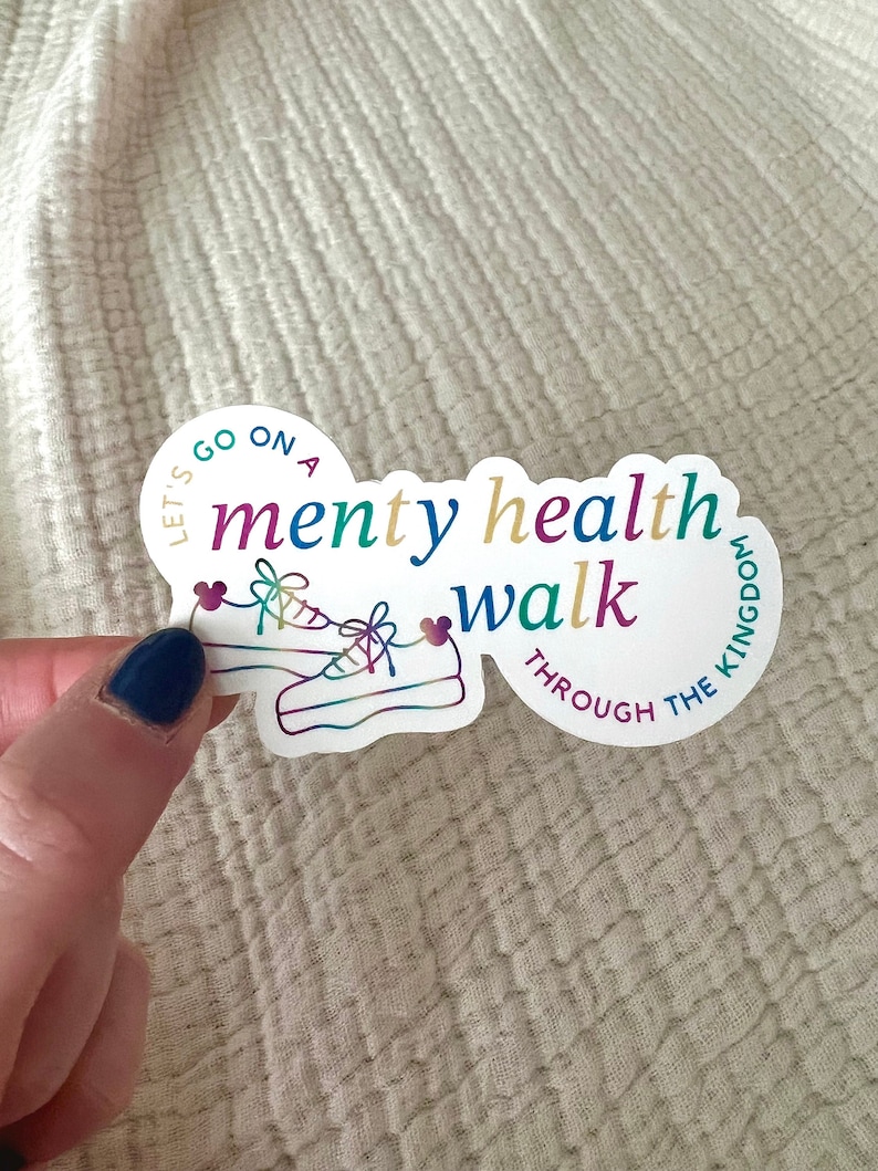 以下が含まれることがあります： 「Let's go on a menty health walk through the kingdom」というテキストが書かれたカラフルなステッカー。ステッカーには、靴ひもにハートが付いたスニーカーのペアが描かれています。