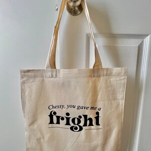 Op de afbeelding: Een beige canvas draagtas met zwarte tekst die "Chessy, you gave me a fright" zegt.