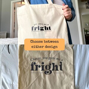 Op de afbeelding: Twee tote bags met de tekst "you gave me a fright" erop gedrukt. E&eacute;n tas is wit en de andere is beige. De tekst is zwart en heeft een vet, speels lettertype.