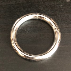 May include: A silver metal ring with a smooth, polished finish.