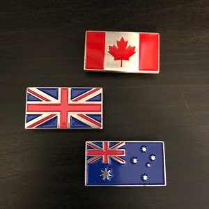 May include: Three metal flag pins, each featuring a different country's flag. The flags are Canada, the United Kingdom, and Australia. The pins are silver with red, white, and blue enamel.