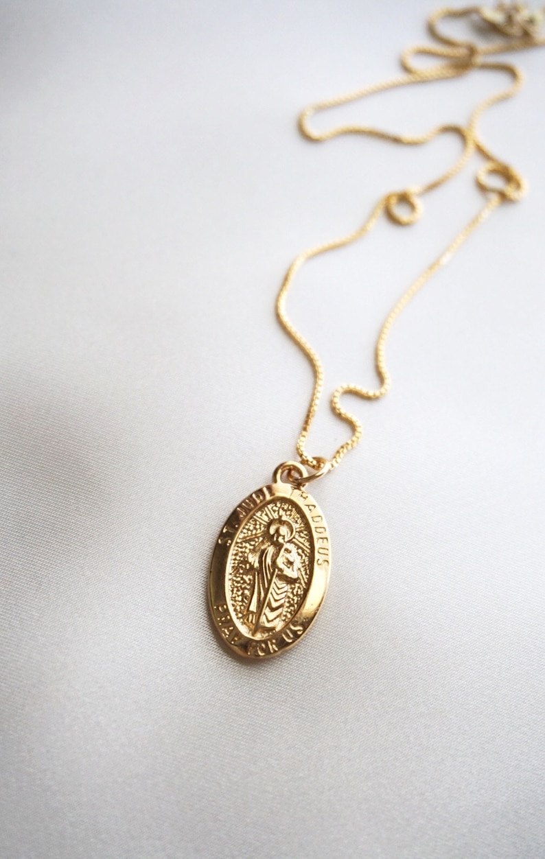 K&ouml;nnte beinhalten: Goldkette mit einem ovalen Anh&auml;nger aus Gold, der ein religi&ouml;ses Bild des Heiligen Judas Thadd&auml;us zeigt. Der Anh&auml;nger tr&auml;gt die Inschriften "Heiliger Judas Thadd&auml;us" und "Bitte f&uuml;r uns".