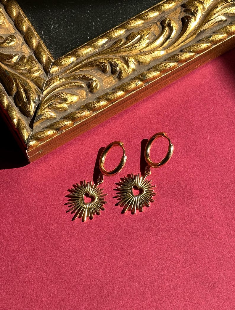Flaming heart pendants on gold hoop earrings