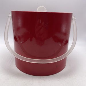 May include: A red ice bucket with clear plastic handles. The bucket has a glossy finish.