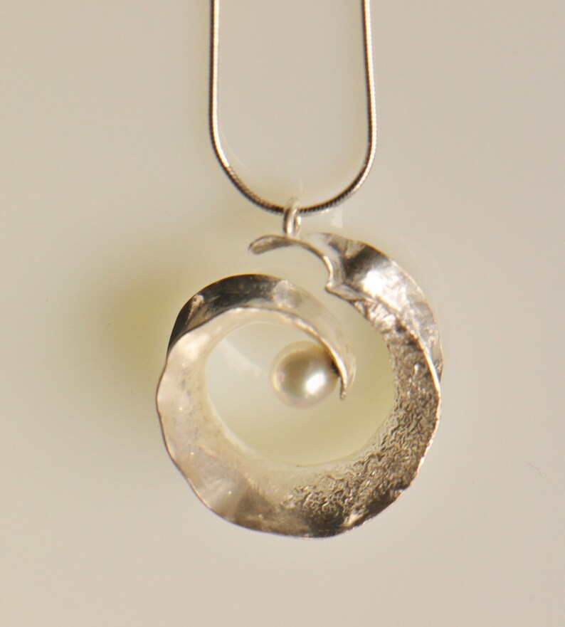 Anticlastic three-dimensional spiral pendant in sterling silver with white freshwater pearl