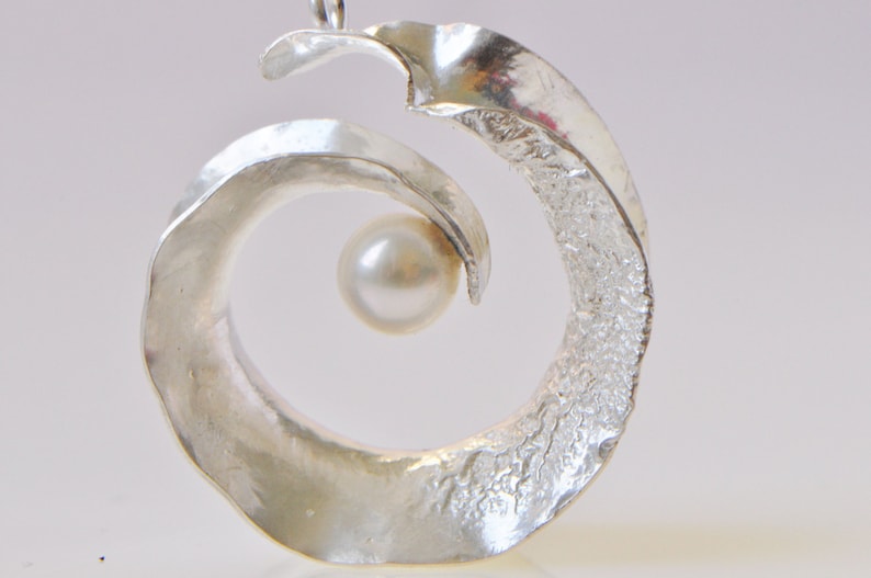 Anticlastic three-dimensional spiral pendant in sterling silver with white freshwater pearl