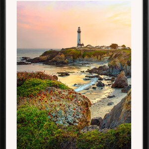 May include: A white lighthouse stands tall on a rocky cliff overlooking a calm ocean. The sky is a vibrant mix of pink, orange, and purple, creating a beautiful sunset scene.