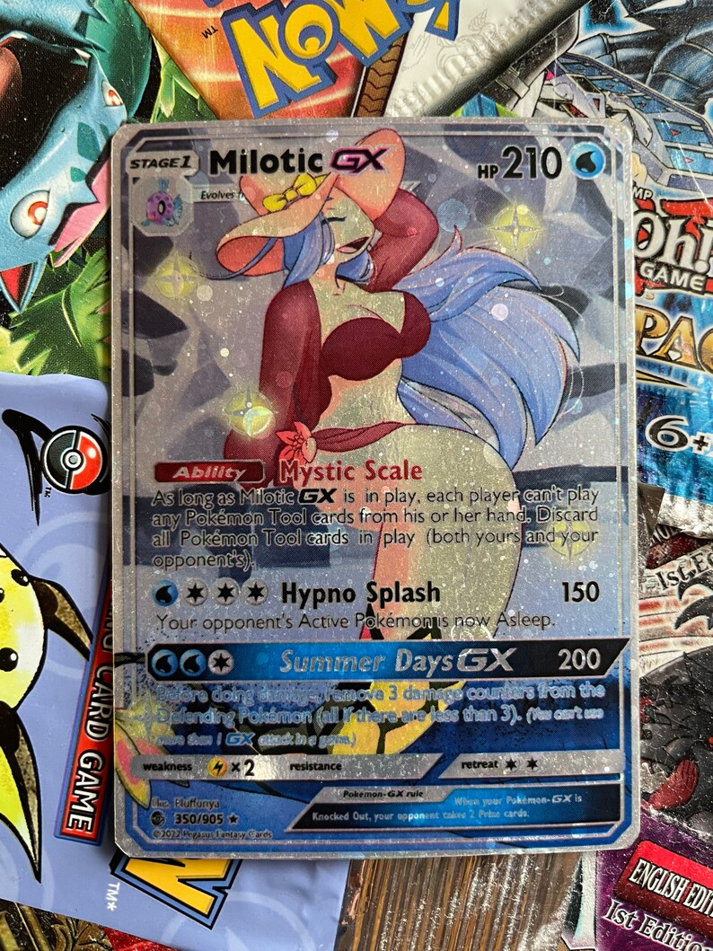 May include: A holographic Pokemon trading card featuring Milotic GX, a water-type Pokemon with a pink hat and blue hair. The card has a light blue background with silver glitter. The card text reads "Mystic Scale", "Hypno Splash", and "Summer Days GX".