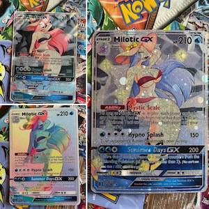 May include: Three holographic Pokemon trading cards featuring Milotic GX. The cards are in the Summer Days GX set and have a holographic background with a pink, blue, and purple color scheme. The cards feature the text "Mystic Scale", "Hypno Splash", and "Summer Days GX".